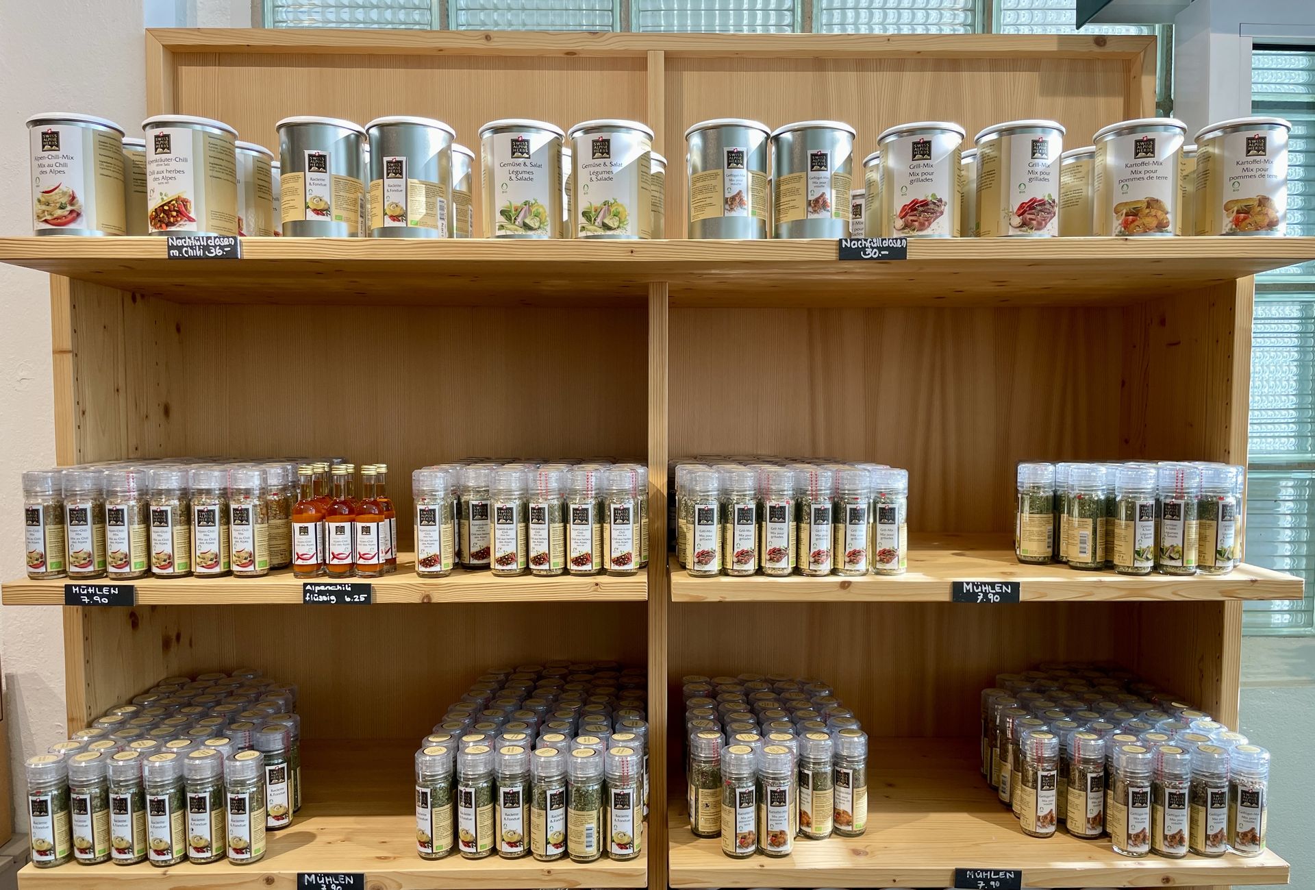 Retail shelf displaying the Swiss Alpine Herbs product portfolio: teas, spices, and syrups.