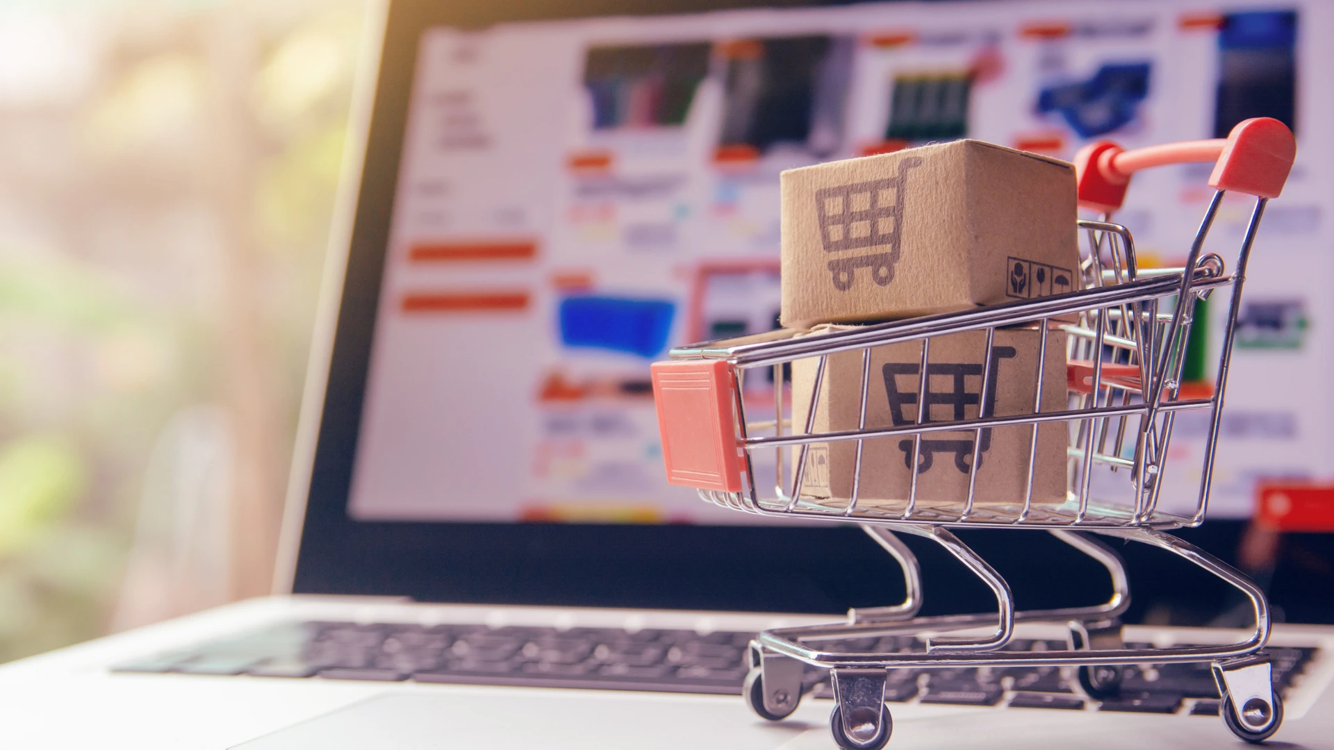 Carrello e-commerce online con pacchi davanti a computer portatile - vendita online con Odoo