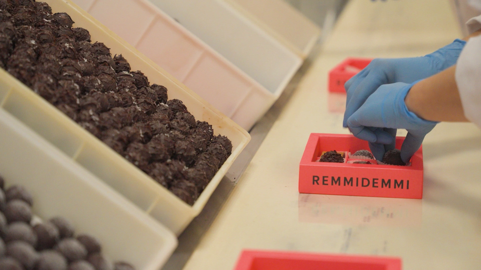 Close up showing hands of a worker packaging chocolate into a gift box