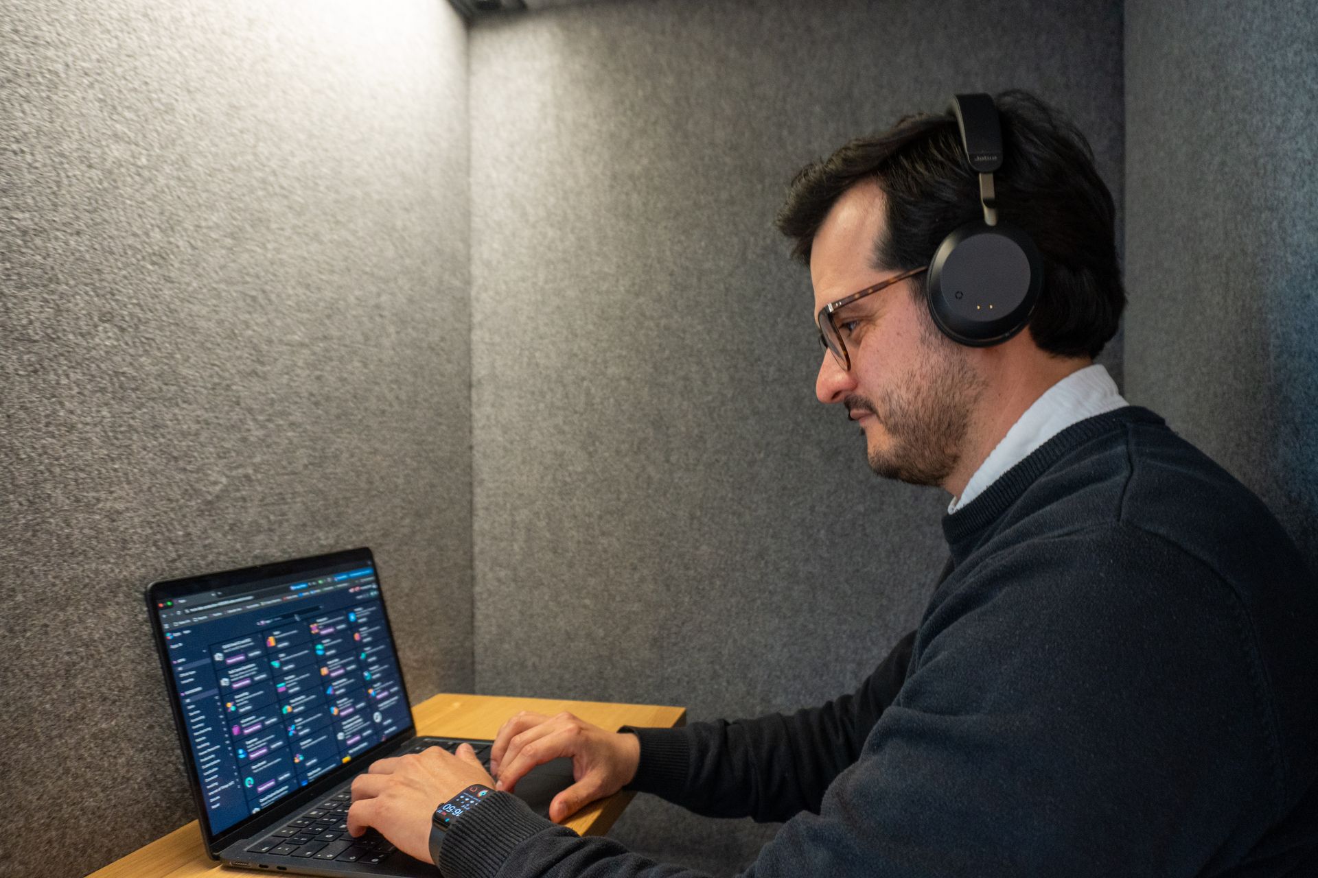 A professional working focused inside a mute-labs soundproof booth using Odoo for task management.