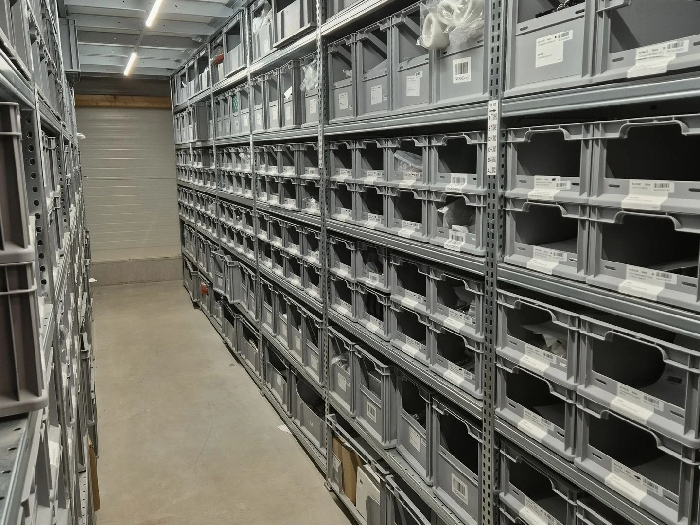 Organized small parts storage at ENFIDO with barcodes for digital tracking via Odoo.